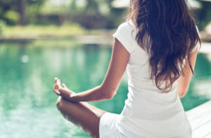 woman meditating poolside frontpage wellness